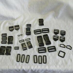 35 plastic backpack fasteners, all black except one navy blue